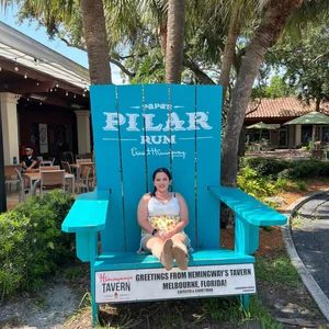 Rachel sitting in a giant blue chair outside a tavern in Melbourne, Florida